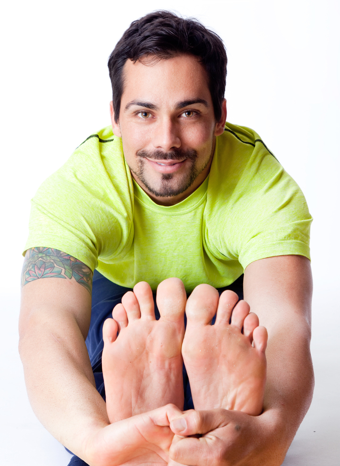 Male yogi with hands around his feet