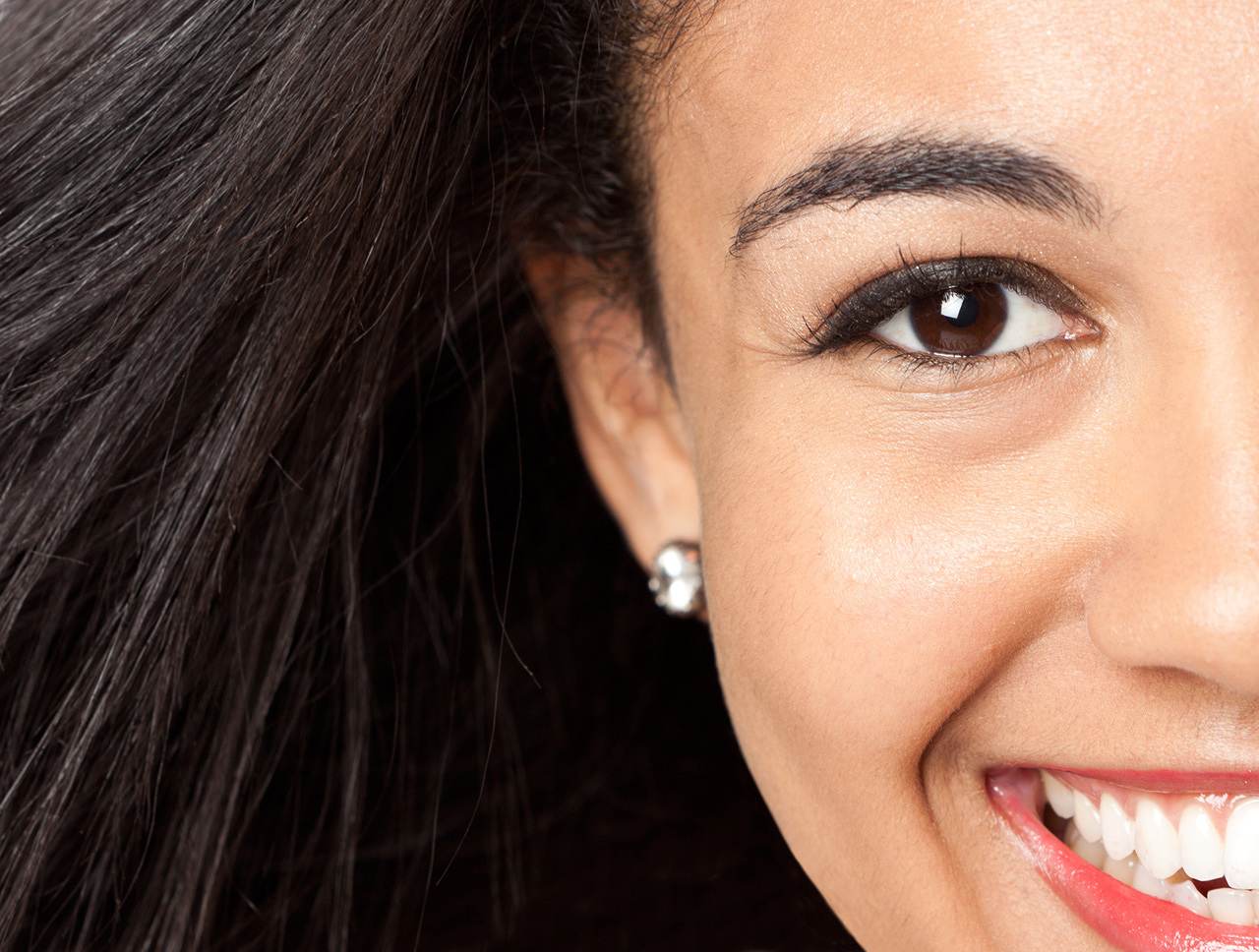 Close-up of eye of dark haired young happy woman